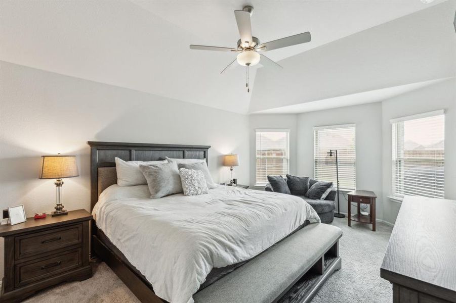 Primary Bedroom featuring high vaulted ceiling, bay windows and ceiling fan Primary Bedroom featuring high vaulted ceiling, bay windows and ceiling fan