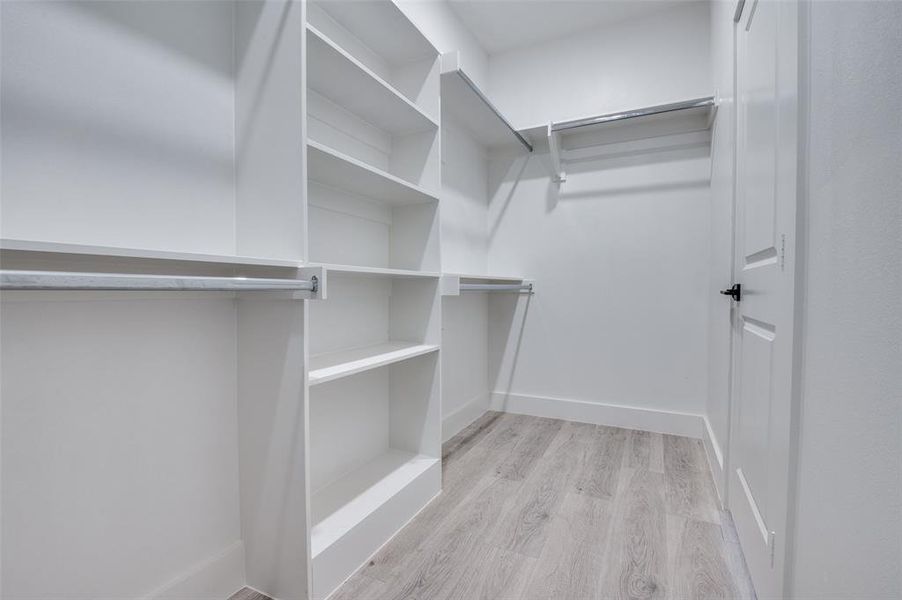Walk in closet featuring wood finished floors Walk in closet featuring wood finished floors