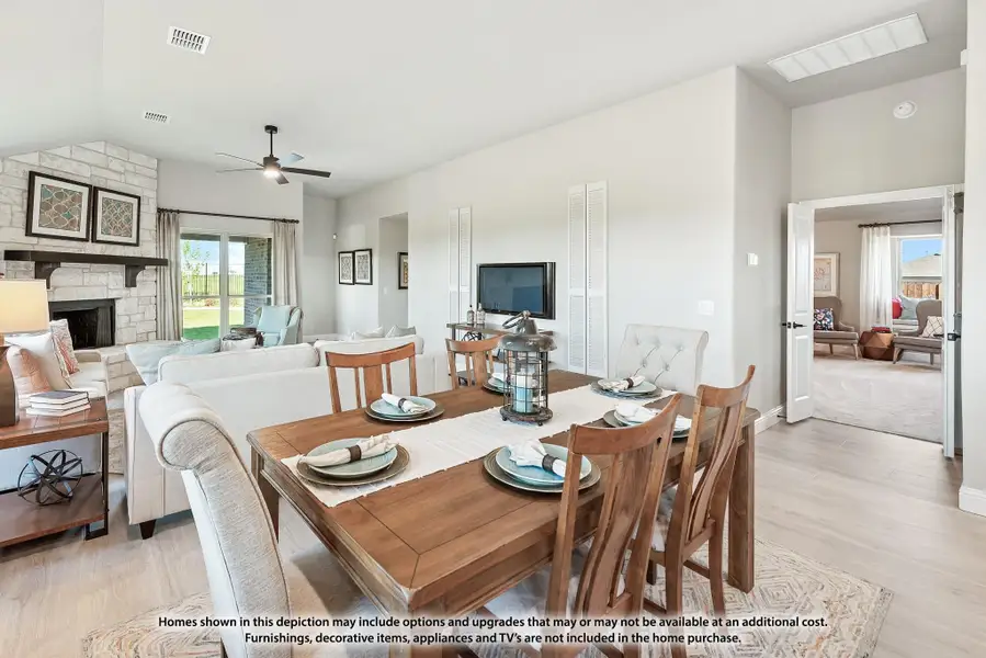Open-plan dining and living area with wood table, stone fireplace, and ceiling fan Open-plan dining and living area with wood table, stone fireplace, and ceiling fan