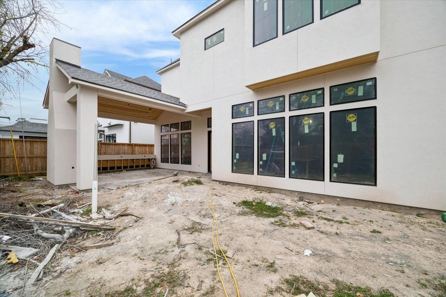 Expansive backyard view showcasing the home’s striking contemporary architecture and clean white stucco exterior. Large windows and sleek black-trimmed glass doors create a seamless connection between the indoor and outdoor living spaces, flooding the interior with natural light. This private outdoor area offers a spacious layout with a sophisticated modern aesthetic, providing a perfect canvas for a custom pool, garden, or luxury entertainment space. Expansive backyard view showcasing the home’s striking contemporary architecture and clean white stucco exterior. Large windows and sleek black-trimmed glass doors create a seamless connection between the indoor and outdoor living spaces, flooding the interior with natural light. This private outdoor area offers a spacious layout with a sophisticated modern aesthetic, providing a perfect canvas for a custom pool, garden, or luxury entertainment space.