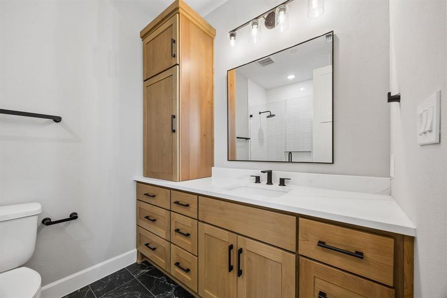 Bathroom with vanity, a shower stall, and dark marble finish floors Bathroom with vanity, a shower stall, and dark marble finish floors