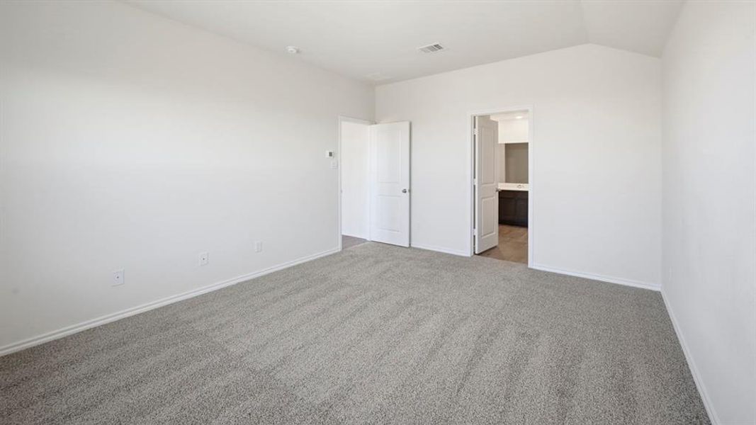 Unfurnished bedroom with carpet floors, lofted ceiling, and ensuite bathroom