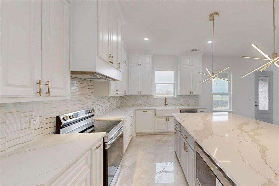 Kitchen featuring appliances with stainless steel finishes, light stone counters, decorative backsplash, recessed lighting, and white cabinets