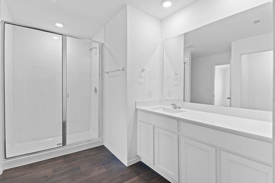 Bathroom with recessed lighting, visible vents, a stall shower, vanity, and wood finished floors