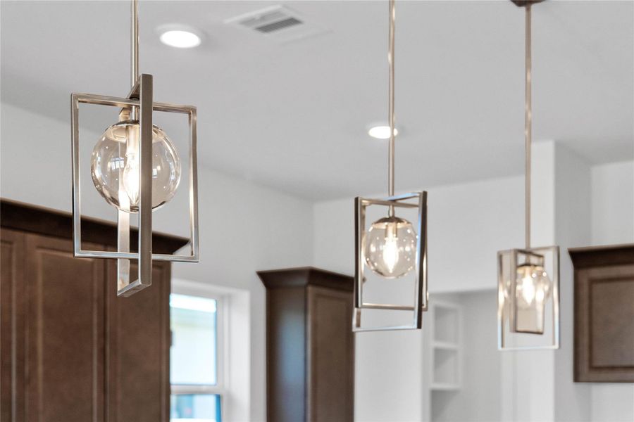 Contemporary pendant lights hang above the island, adding a touch of modern design, complemented by recessed lighting throughout the ceiling for overall illumination. Contemporary pendant lights hang above the island, adding a touch of modern design, complemented by recessed lighting throughout the ceiling for overall illumination.