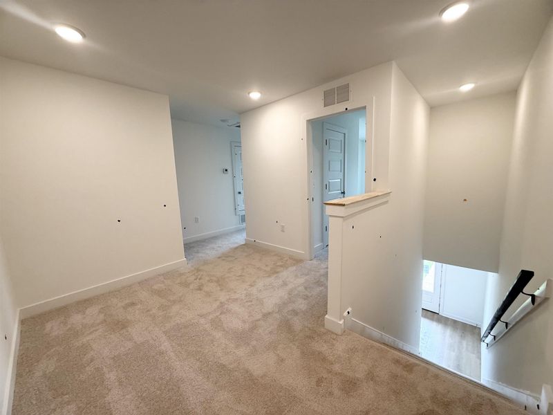 Hall with light colored carpet, recessed lighting, and baseboards Hall with light colored carpet, recessed lighting, and baseboards