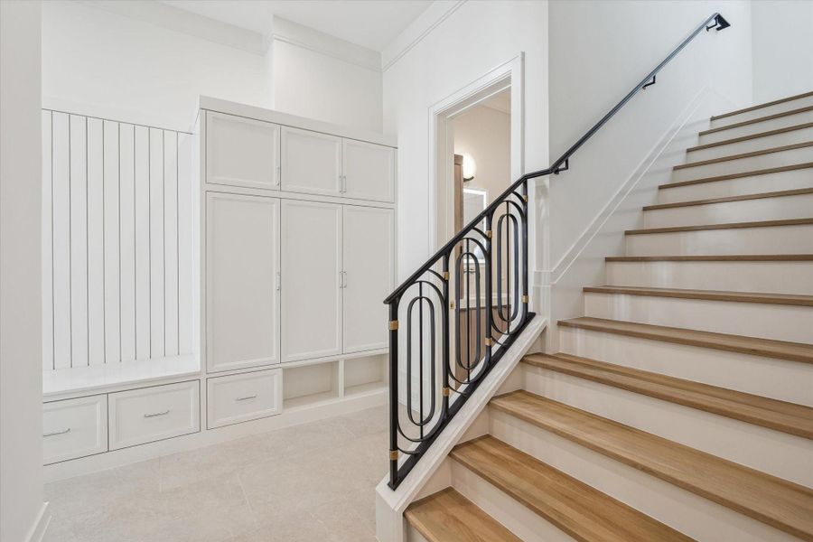 Mud room located by the secondary staircase, providing ample storage closets and a built-in seating bench.