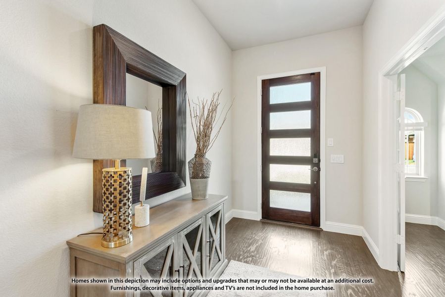 Home entryway with dark wood front door with glass panels, console table, and hardwood floors Home entryway with dark wood front door with glass panels, console table, and hardwood floors