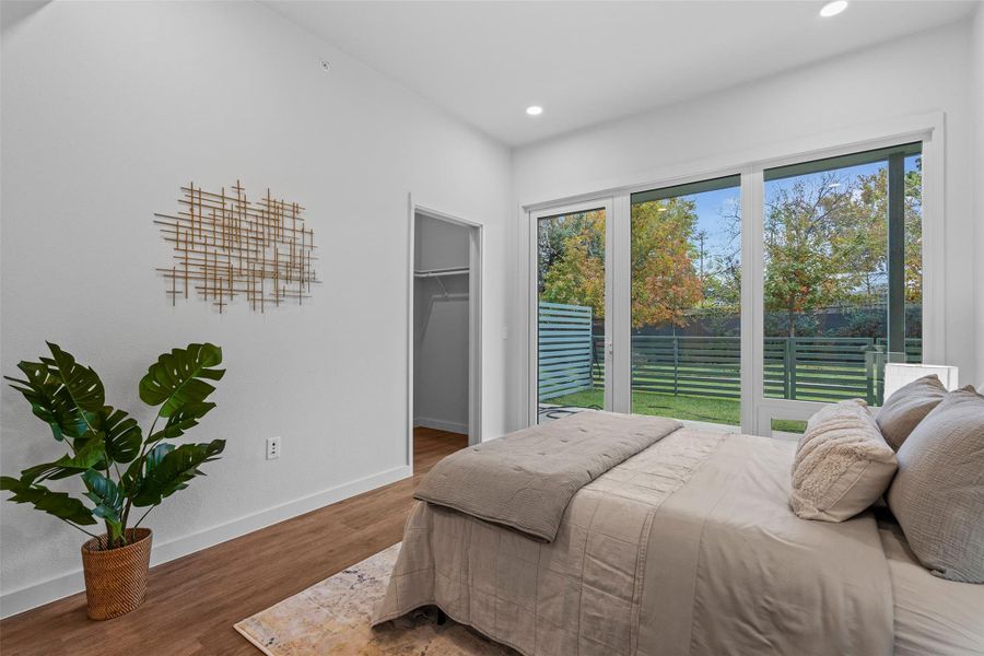 Bedroom featuring recessed lighting, a spacious closet, baseboards, and wood finished floors