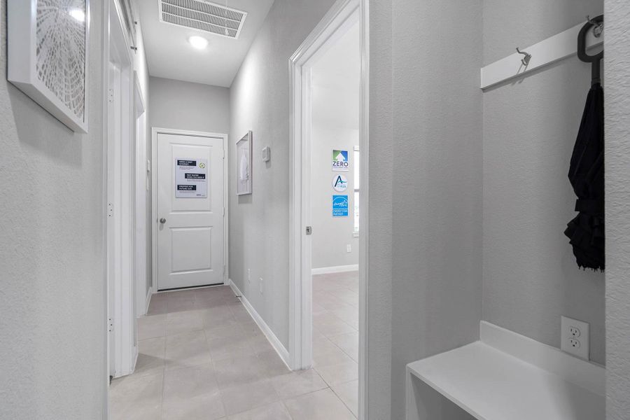 Enjoy the efficiency of this well-lit hallway area featuring a custom bench and hooks, providing a perfect spot to unload bags and coats upon entering the home.