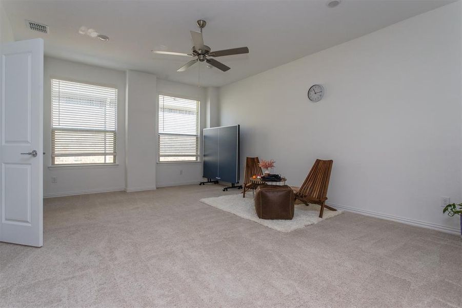 Sitting room featuring light carpet and ceiling fan