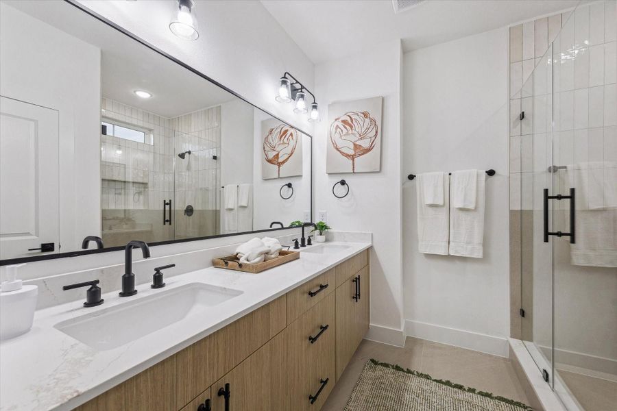 Primary bathroom featuring dual vanities and walk-in shower Primary bathroom featuring dual vanities and walk-in shower