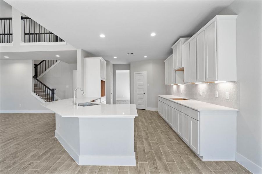 This kitchen is by far any chef’s dream! This spacious kitchen features high ceilings, stained wood cabinets, quartz countertops, SS appliances, modern tile backsplash, recessed lighting, extended counter space, extra space for breakfast bar, and a walk-in pantry all overlooking your huge family room.