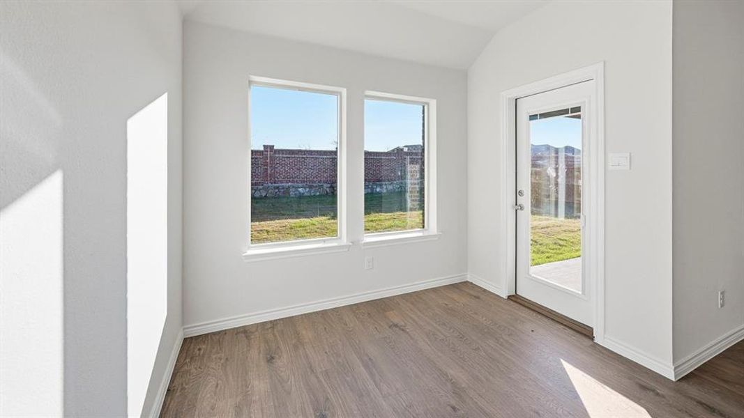 This bright room features two windows and a glass-paned door, offering views of the exterior