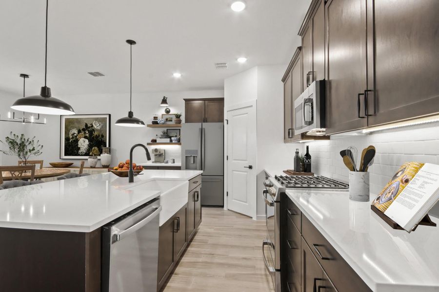 Stunning kitchen with dark stain cabinets and quartz counters (*Photo not of actual home and used for illustration purposes only.)