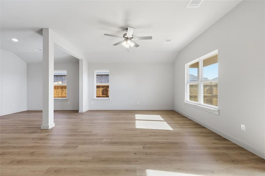 Unfurnished living room featuring light wood-style floors, plenty of natural light, and ceiling fan