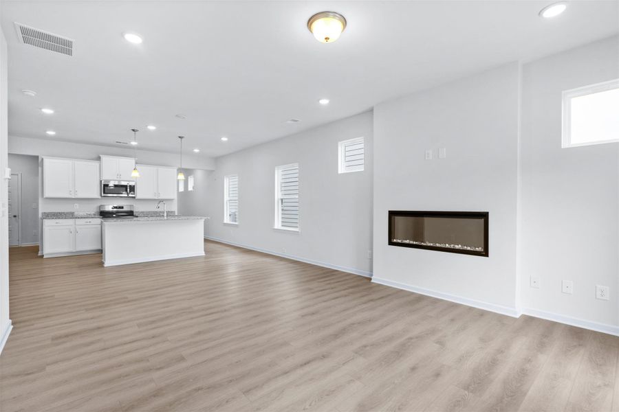 The Dove- Family Room into the Kitchen. Home under construction, photo used for illustrative purposes only, colors and options will vary.