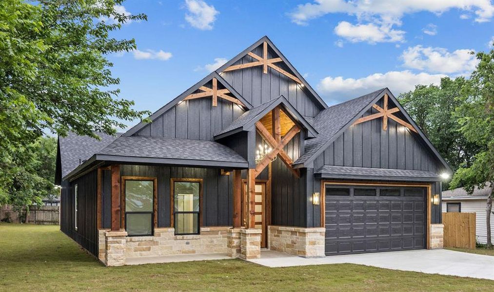 Modern farmhouse exterior featuring dark vertical siding, contrasting stone veneer, and prominent exposed timber accents Modern farmhouse exterior featuring dark vertical siding, contrasting stone veneer, and prominent exposed timber accents