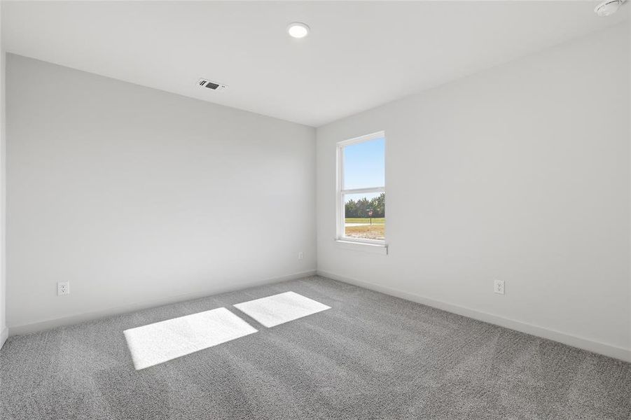 Bright interior space featuring a single window, recessed lighting, and grey carpet flooring
