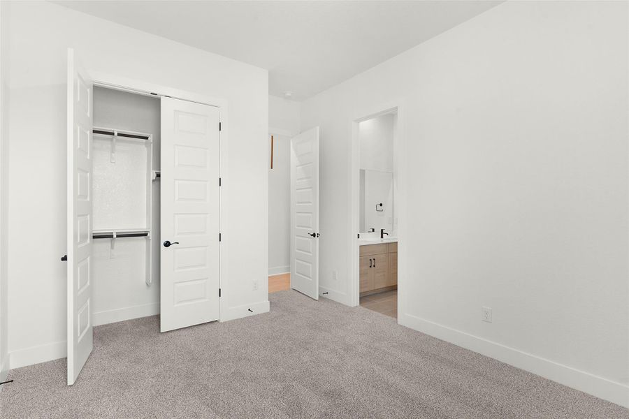 Unfurnished bedroom with a closet, ensuite bathroom, and light carpet Unfurnished bedroom with a closet, ensuite bathroom, and light carpet