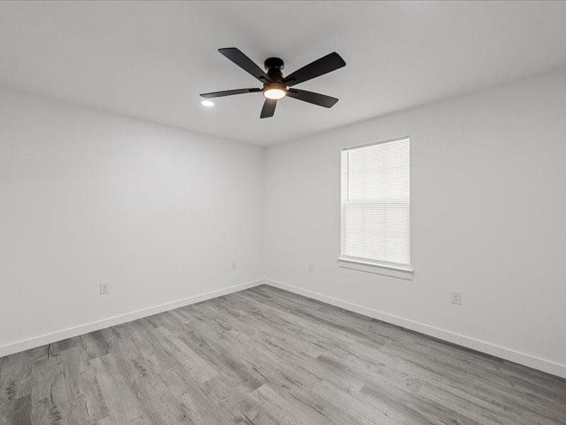 Spare room with light wood finished floors and ceiling fan
