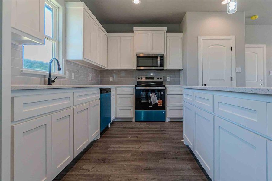 Kitchen featuring appliances with stainless steel finishes, decorative backsplash, white cabinetry, and recessed lighting Kitchen featuring appliances with stainless steel finishes, decorative backsplash, white cabinetry, and recessed lighting