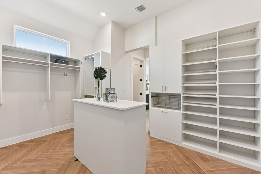 Walk in closet with parquet flooring