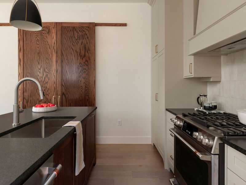 Warm wood tones complement sleek stainless appliances in this inviting, naturally lit culinary space.