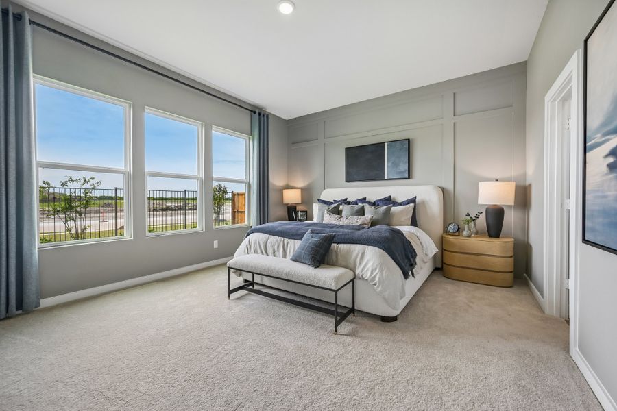 A bedroom with a bed and a bench.