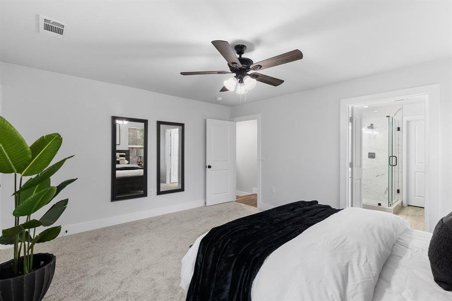 Bedroom featuring ensuite bath, ceiling fan, and light colored carpet