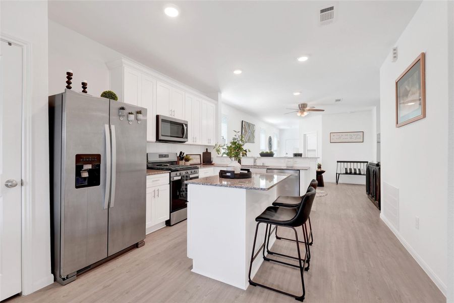 Fall in love with a modern chef’s kitchen featuring stainless-steel appliances, sleek cabinetry, ample counter space, and a large breakfast bar, creating a perfect balance of beauty and functionality.