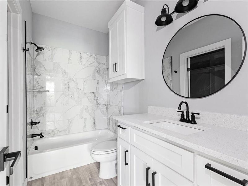 Bathroom with vanity, toilet, bathing tub / shower combination, and wood finished floors