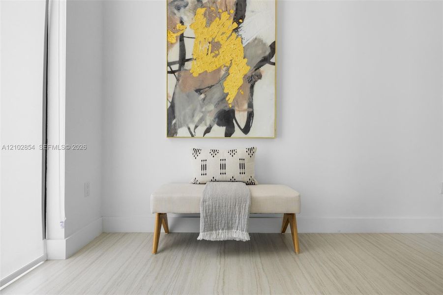 Neutral-toned, wood-finish flooring contrasted with crisp white walls