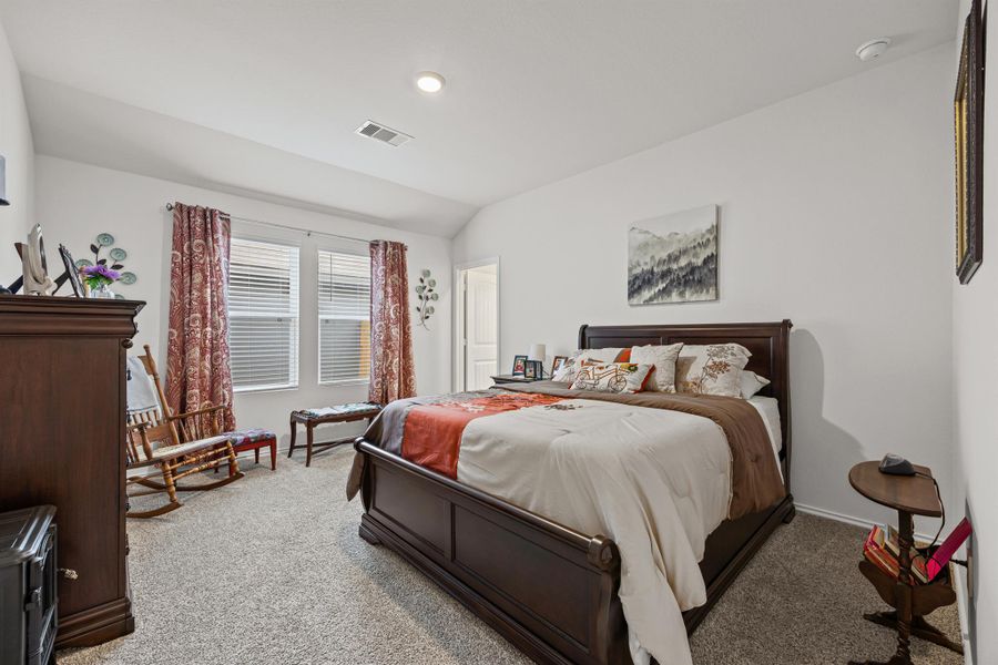 Bedroom with vaulted ceiling and light colored carpet