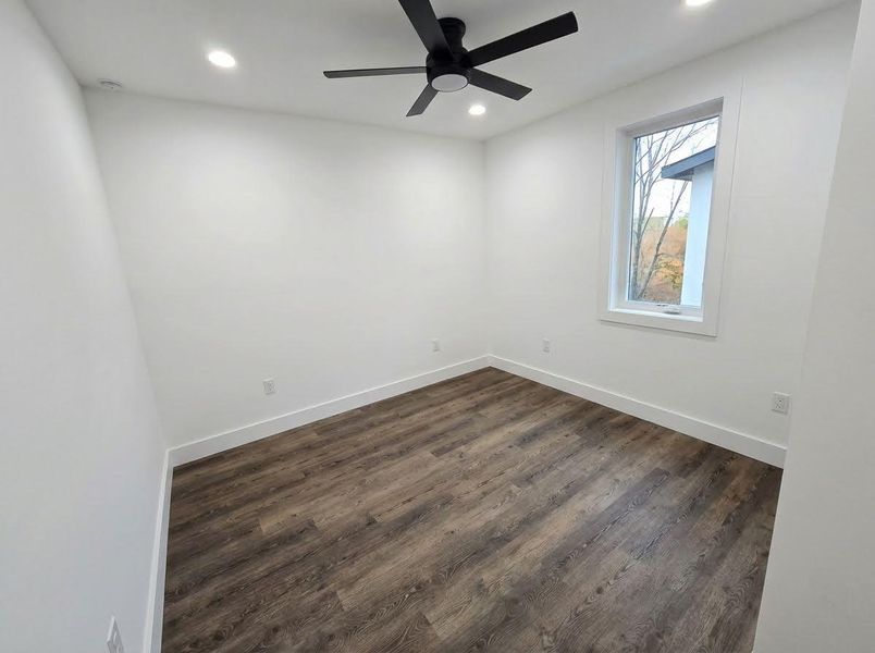 Empty room featuring dark wood finished floors, recessed lighting, and ceiling fan