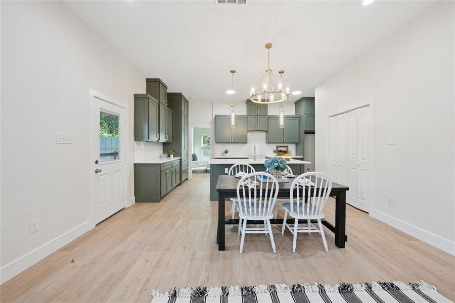 Dining area with recessed lighting, light wood-type flooring, and a chandelier