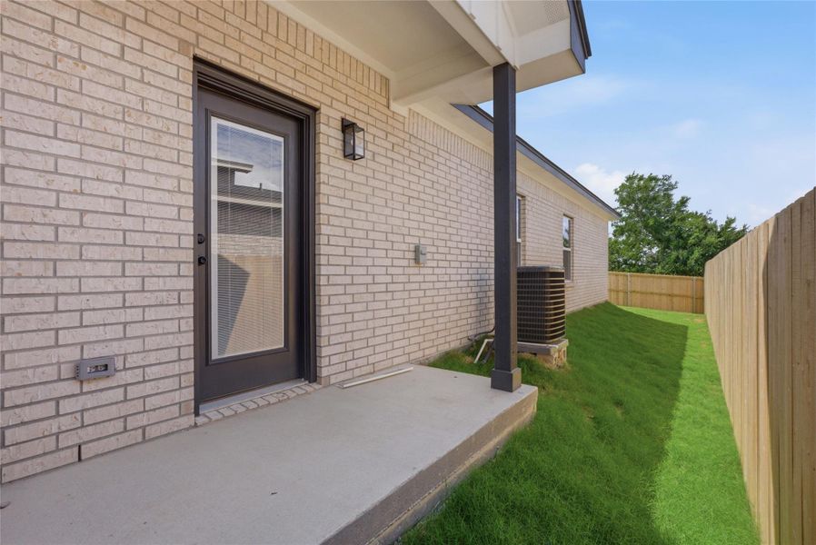Entrance to property with a patio area and brick siding