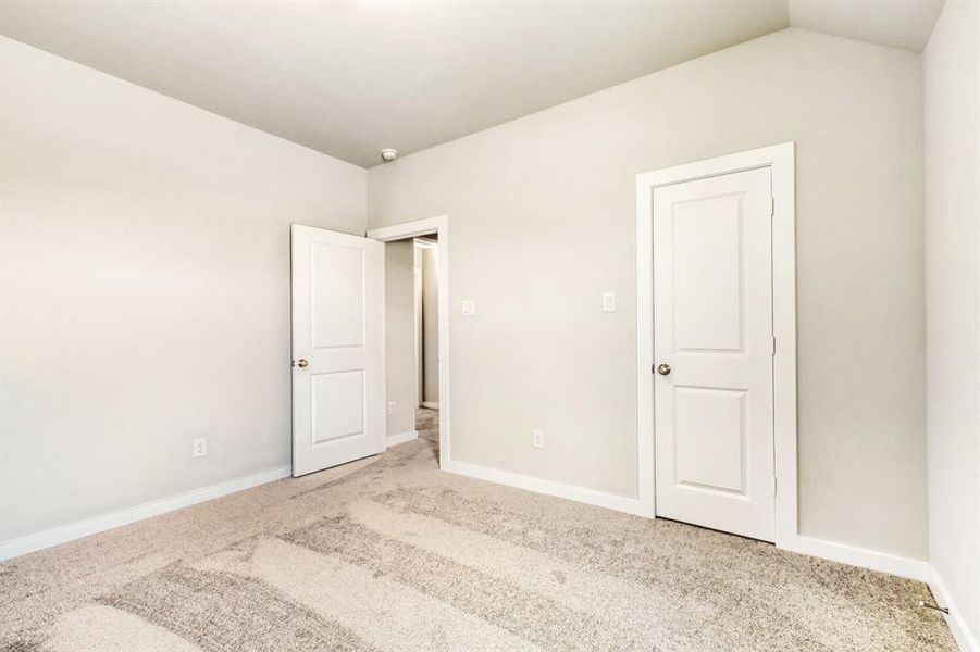 Unfurnished bedroom featuring light colored carpet and baseboards