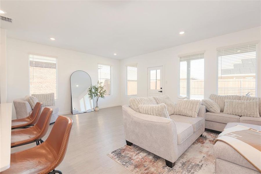Living area with light wood-style flooring, recessed lighting, and plenty of natural light Living area with light wood-style flooring, recessed lighting, and plenty of natural light