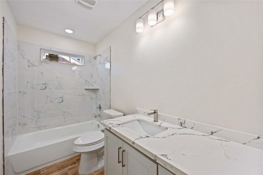 Full secondary bathroom with modern finishes and a shower/tub combo.
