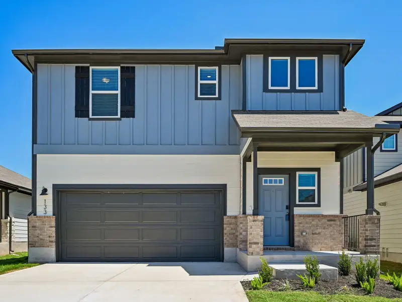 Front exterior of a new home in Travena - Americana Collection, Georgetown, TX, highlighting curb appeal (Image 1). Front exterior of a new home in Travena - Americana Collection, Georgetown, TX, highlighting curb appeal (Image 1).