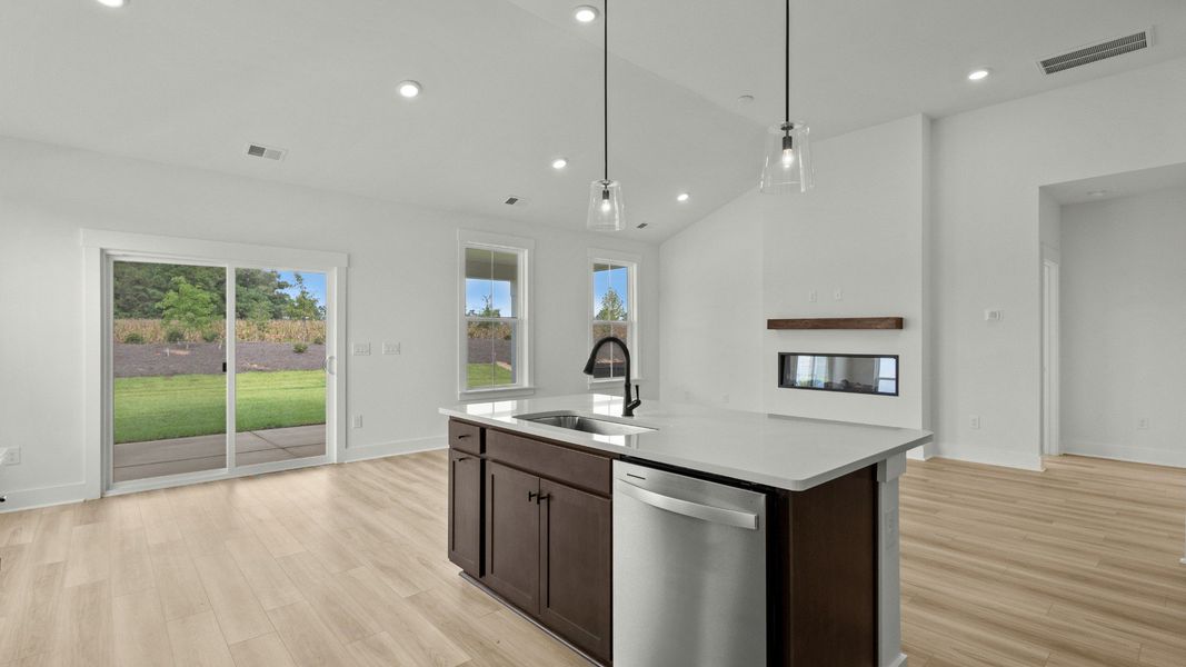 Kitchen and living room with porch access at Chestnut Farms by DRB Homes