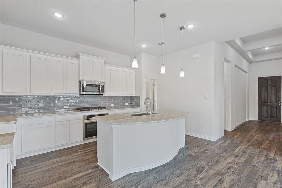 Kitchen with white cabinets, appliances with stainless steel finishes, and sink