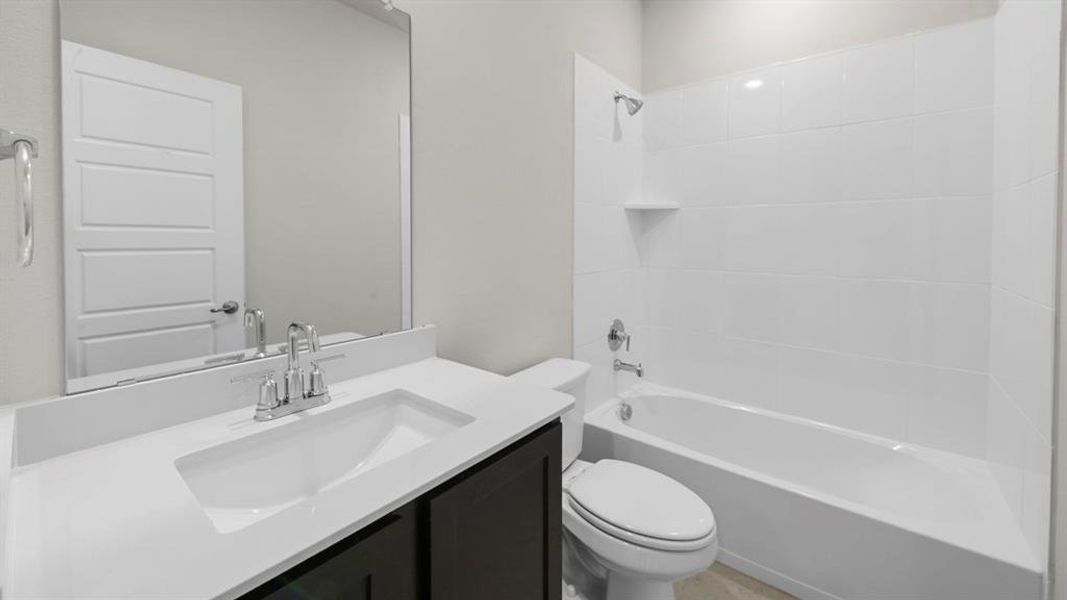 Bathroom featuring a white integrated sink, chrome faucet, and dark wood-finish vanity Bathroom featuring a white integrated sink, chrome faucet, and dark wood-finish vanity