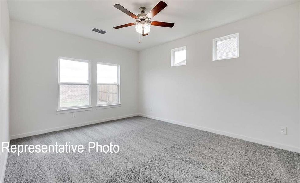 Carpeted spare room featuring ceiling fan