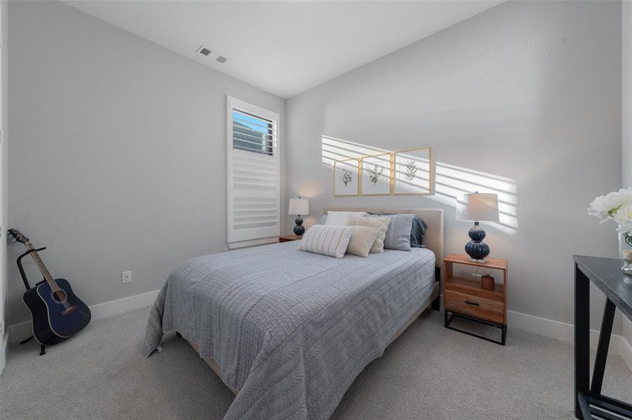 Bedroom featuring carpet floors, lofted ceiling, visible vents, and baseboards