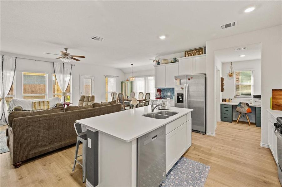 Kitchen with sink, a center island with sink, a healthy amount of sunlight, and appliances with stainless steel finishes