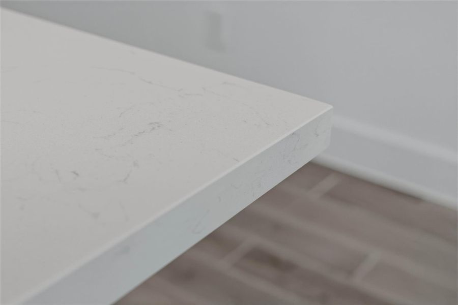 Premium quartz countertops on the island provide a durable, non-porous surface that is as functional for meal prep as it is beautiful. Premium quartz countertops on the island provide a durable, non-porous surface that is as functional for meal prep as it is beautiful.