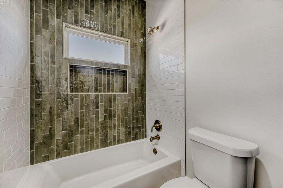 The wet room is conveniently private and features a shower/tub combo with designer tile backsplash.