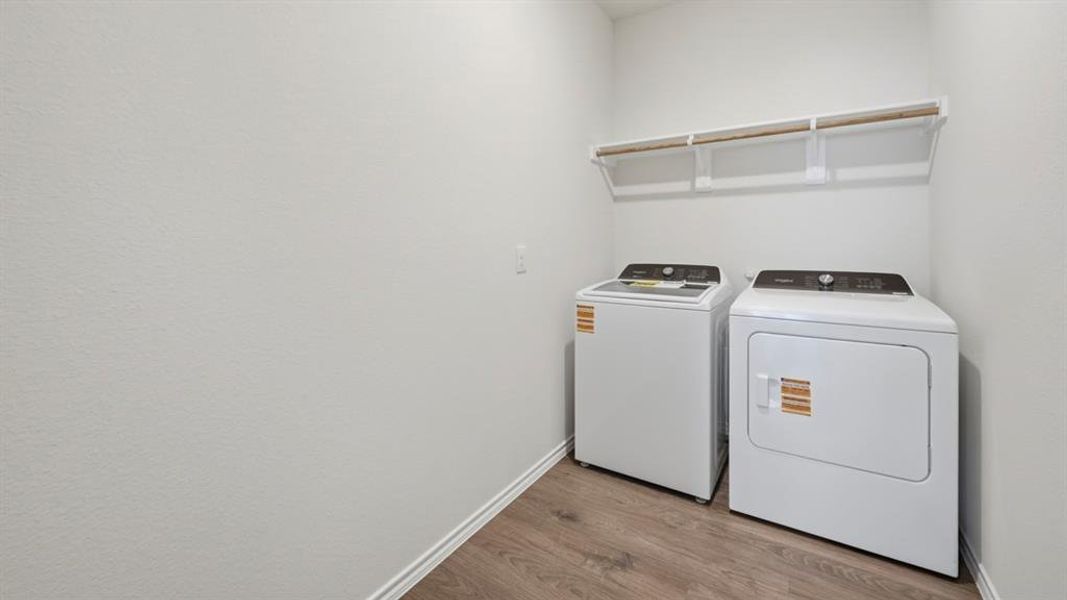 Washroom featuring light wood-style flooring and washer and clothes dryer